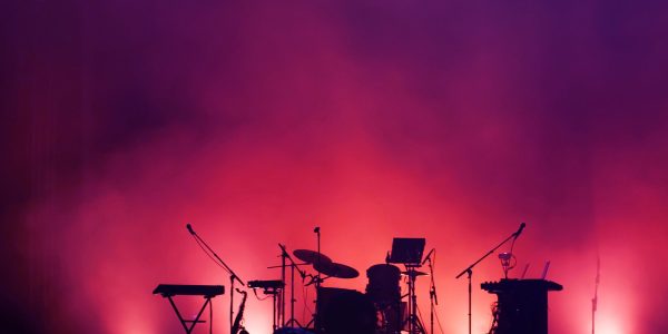 concert stage on rock festival, music instruments silhouettes, colorful background with copy space